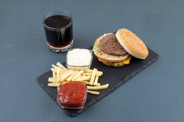 Kızarmış patates ve hamburger dolu ahşap bir tahta. Yüksek kalite fotoğraf