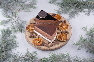 İki dilim pasta, portakal dilimleri ve tahtanın üzerinde kahve çekirdekleri. Yüksek kalite fotoğraf