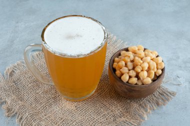 Çuval bezin üzerinde bezelye dolu küçük bir kase dolusu bira. Yüksek kalite fotoğraf