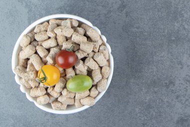 Çavdar gevreği ve renkli domateslerle dolu beyaz bir kase. Yüksek kalite fotoğraf