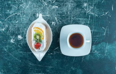 Bir parça kremalı kek ve bir fincan sıcak çay. Yüksek kalite fotoğraf