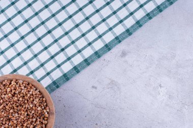 Mütevazı bir kâse karabuğday, mermer zemine yayılmış havluya serilmiş. Yüksek kalite fotoğraf