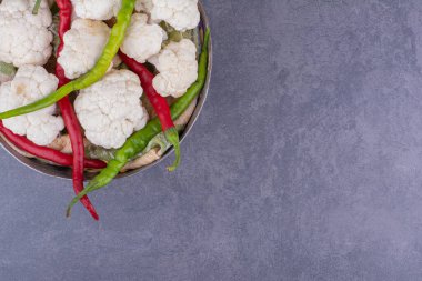 Mavi arka planda bir kasede karnabahar ve kırmızı biber. Yüksek kalite fotoğraf