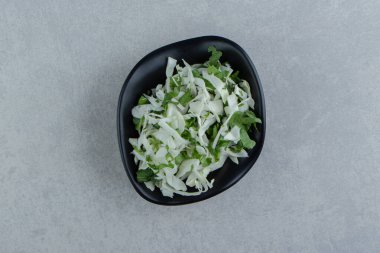 Dilimlenmiş yeşillikler ve lahana kasede, mermer arka planda. Yüksek kalite fotoğraf