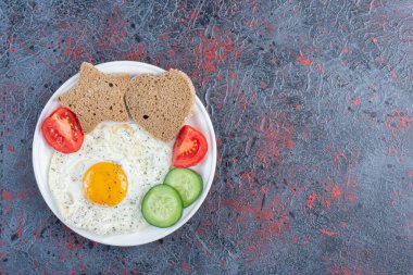 Yumurtalı kahvaltı tabağı, salatalık, domates ve ekmek dilimleri. Yüksek kalite fotoğraf