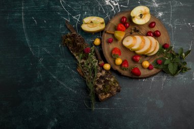 Tahta nesneler üzerindeki taze meyveler izole edilmiş mermer arka plan