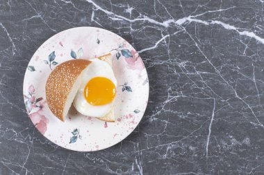 Lezzetli çörek ve yumurta tabakta, mermer arka planda. Yüksek kalite fotoğraf