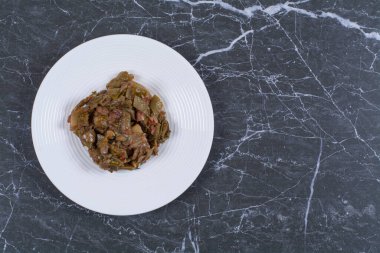 Siyah arka planda beyaz tabakta marine edilmiş sebzeler. Yüksek kalite fotoğraf