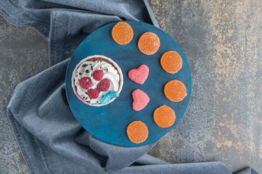 Mavi panoda krema ve şekerle süslenmiş lezzetli bir kek. Yüksek kalite fotoğraf