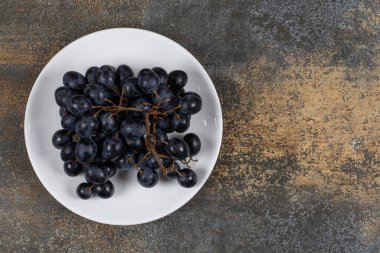 Beyaz tabakta siyah üzüm kümesi. Yüksek kalite fotoğraf