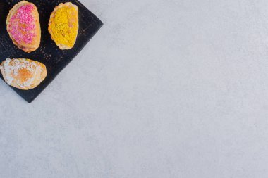 Siyah tahtada renkli hindistan cevizleriyle süslenmiş lezzetli bisküviler. Yüksek kalite fotoğraf