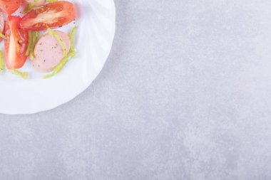 Taş zeminde dilimlenmiş sosis ve domates tabağı. Yüksek kalite fotoğraf