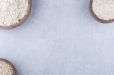 Yulaf ve kısa tahıllı pirinç mermer arka planda ahşap kaseler şeklinde porsiyonlu. Yüksek kalite fotoğraf