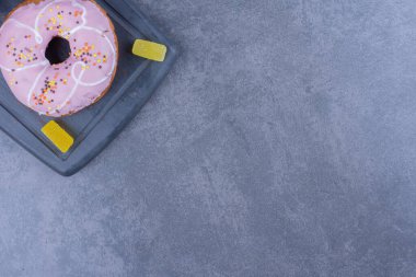 Donut ve jöleli şekerlemelerle dolu karanlık bir tahta. Yüksek kalite fotoğraf