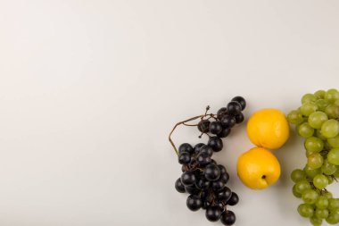 Altında sarı şeftali olan yeşil ve kırmızı üzüm demetleri. Yüksek kalite fotoğraf