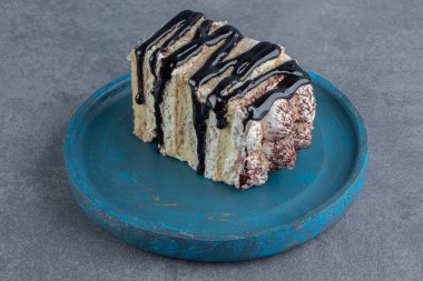 Mavi tabakta çikolatalı kremalı bir pasta. Yüksek kalite fotoğraf