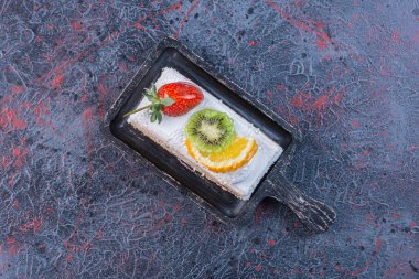 Soyut arkaplanda siyah bir tahtada meyveli kek dilimi. Yüksek kalite fotoğraf