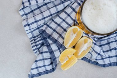 Masa örtüsünde limon dilimleri olan bir bardak bira. Yüksek kalite fotoğraf