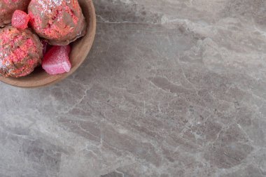 Küçük bir kasede mermer arka planda atıştırmalık kekler ve marmelatlar. Yüksek kalite fotoğraf