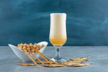 Gri arka planda bezelyeli bir bardak bira ve balık. Yüksek kalite fotoğraf