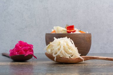 İki kaşık lahana ve ahşap bir kase tuzlu sebze. Yüksek kalite fotoğraf