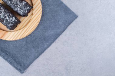 Çikolatalı pasta mermer arka planda bir havluyla ahşap bir tabakta dilimler. Yüksek kalite fotoğraf