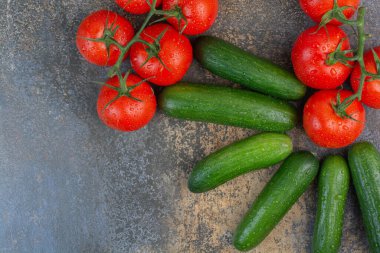 Mermer arka planda bir avuç domates ve salatalık. Yüksek kalite fotoğraf