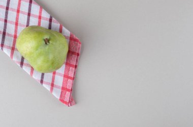 Katlanmış havluyla mermer zemin üzerinde tek bir armut. Yüksek kalite fotoğraf