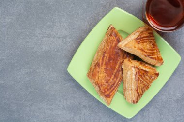 Yeşil tabakta hamur işleriyle birlikte bir bardak çay. Yüksek kalite fotoğraf