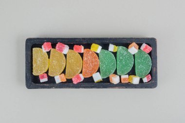 Renkli şekerli marmelatlarla dolu koyu ahşap bir tahta. Yüksek kalite fotoğraf