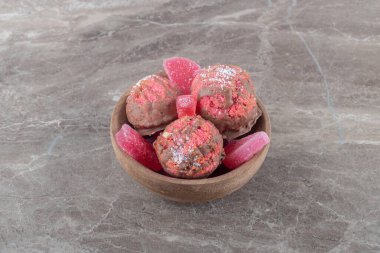 Küçük bir kasede mermer arka planda atıştırmalık kekler ve marmelatlar. Yüksek kalite fotoğraf