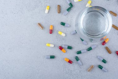 Çeşitli ilaç kapsülleri ve bir bardak su. Yüksek kalite fotoğraf