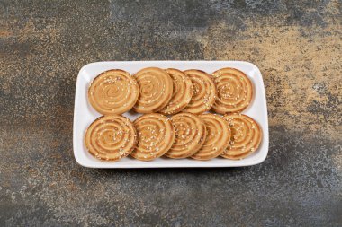 Beyaz tabakta susam tohumlu lezzetli bisküviler. Yüksek kalite fotoğraf