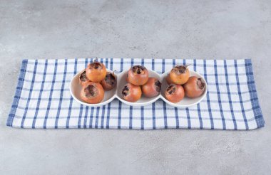 Masa örtüsünde taze hurma olan beyaz tabaklar. Yüksek kalite fotoğraf