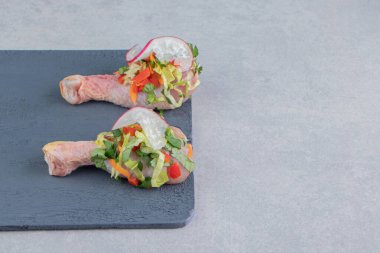 Tahtada, mermer zeminde marine edilmiş tavuk budu var. Yüksek kalite fotoğraf