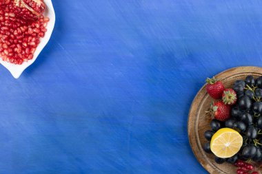 Mavi zemin üzerinde nar dolu beyaz bir tabak. Yüksek kalite fotoğraf