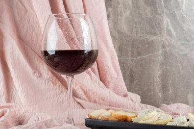 Mermer zemin üzerinde peynir tabağı olan bir kadeh şarap. Yüksek kalite fotoğraf