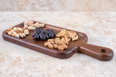 Küçük fındık ve şeker yığınlarıyla servis edilen abur cuburlar mermer arka planda. Yüksek kalite fotoğraf