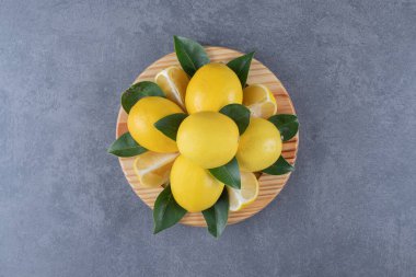 Üst Manzara. Tahta tabakta taze organik limon ve yapraklar yığını. Yüksek kalite fotoğraf