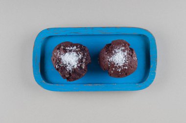 Mermer arka planda mavi bir tabakta iki çikolatalı kek. Yüksek kalite fotoğraf