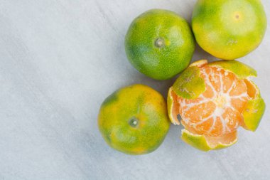 Taş zeminde soyulmuş ve soyulmamış taze mandalinalar. Yüksek kalite fotoğraf