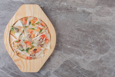 Tahta tabakta, mermer zemin üzerinde et, yeşillik, domates ve makarna karışımı. Yüksek kalite fotoğraf