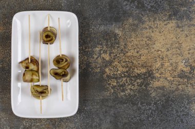 Beyaz kare tabakta çubuk içinde lezzetli patlıcanlar. Yüksek kalite fotoğraf