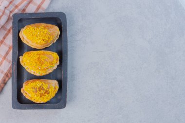 Siyah tabakta sarı hindistan ceviziyle süslenmiş lezzetli bisküviler. Yüksek kalite fotoğraf