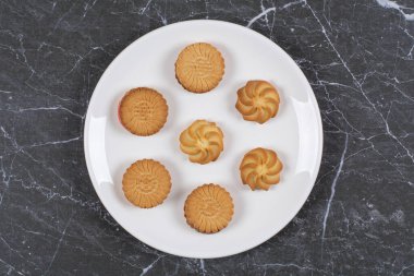 Tabakta çeşitli kurabiyeler var, mermer arka planda. Yüksek kalite fotoğraf