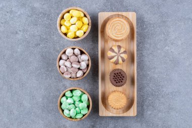 Bir kase şeker ve mermer zemin üzerinde kurabiyeler olan küçük bir tepsi. Yüksek kalite fotoğraf