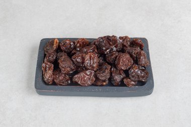 Tahta bir tepside kurumuş kahverengi erikler. Yüksek kalite fotoğraf