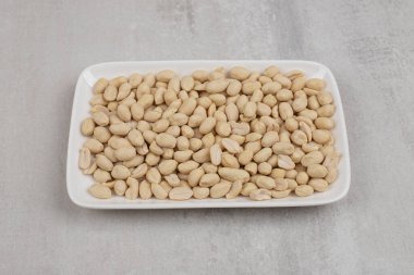 Beyaz tabakta bir sürü soyulmuş fıstık. Yüksek kalite fotoğraf