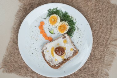 Çuval bezinde haşlanmış yumurta ve tost ile beyaz bir tabak. Yüksek kalite fotoğraf