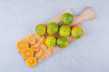 Beyaz arka planda ekşi mandalina dolu tahta kesme tahtası. Yüksek kalite fotoğraf